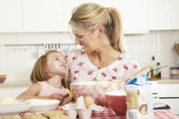 Mother And Daughter Baking In Kitchen