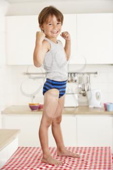 Boy Standing On Kitchen Table In Underwear