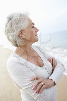Thoughtful Senior Woman Standing On Beach