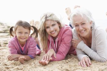 Multi Generation Family Lying On Beach Together