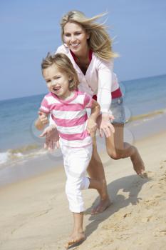 Mother Chasing Daughter Along Beach