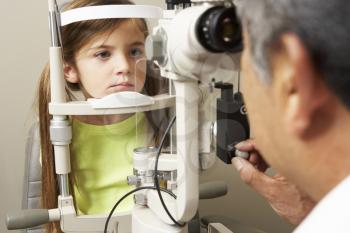 Optician In Surgery Giving Girl Eye Test