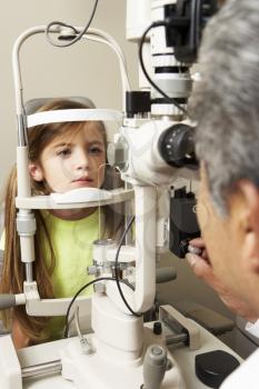 Optician In Surgery Giving Girl Eye Test