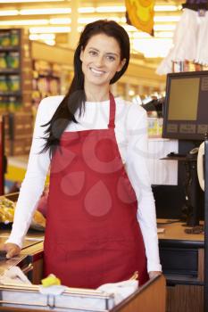 Female Cashier At Supermarket Checkout