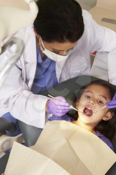 Young Girl Having Check Up At Dentists Surgery