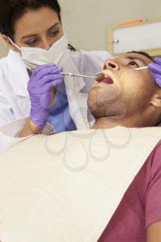 Man Having Check Up At Dentists Surgery