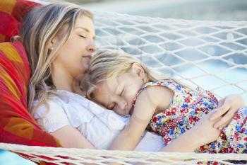 Mother And Daughter Sleeping In Garden Hammock Together