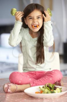 Girl Making Devil Face With Plate Of Fresh Vegetables