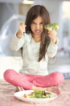 Unhappy Young Girl Rejecting Plate Of Fresh Vegetables