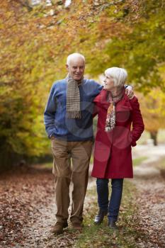 Senior Couple Walking Along Autumn Path