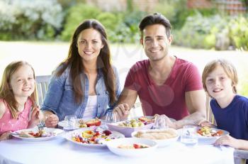 Portrait Of Family Enjoying Outdoor Meal Together
