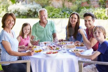 Multi Generation Family Enjoying Outdoor Meal Together
