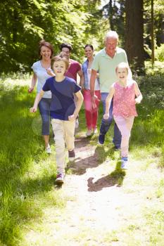 Multi Generation Family Running Through Summer Countryside