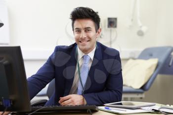 Portrait Of Male Consultant Working At Desk