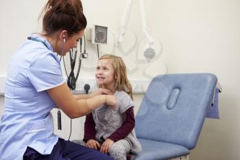 Nurse Examining Young Girl In Hospital