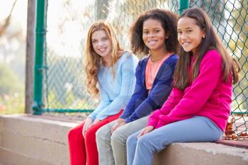 Three Young Girls Hanging Out Together In Park