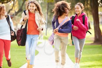 Group Of Young Girls Running Towards Camera In Park