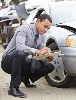 Loss Adjuster Inspecting Car Involved In Accident