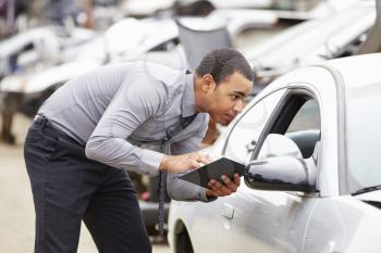 Loss Adjuster Using Digital Tablet In Car Wreck Inspection