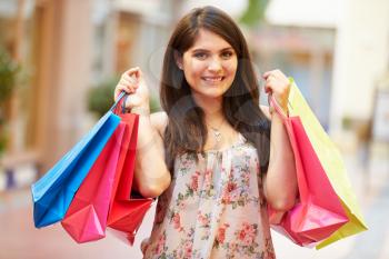 Woman Walking Through Mall Carrying Shopping Bags