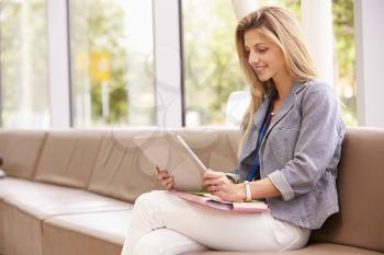 Female College Tutor Looking At Digital Tablet