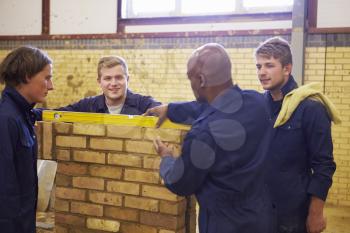 Teacher Helping Students Training To Be Builders