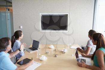 Four Businesspeople Having Video Conference In Boardroom