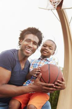 Portrait Of Father And Son On Basketball Court