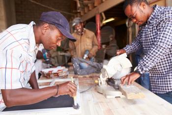 Three men at work in a carpentry workshop, South Africa