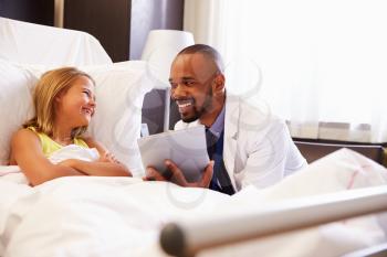 Doctor Talking To Child Patient In Hospital Bed