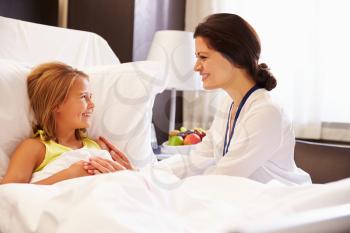 Female Doctor Talking To Child Patient In Hospital Bed