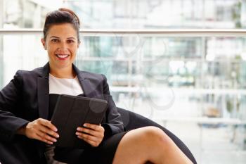 Businesswoman holding tablet computer, looking to camera