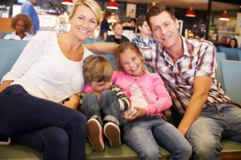 Family In Airport Departure Lounge Waiting To Go On Vacation