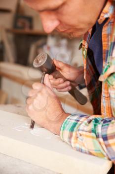 Close Up Of Stone Mason At Work On Carving In Studio
