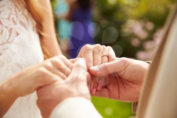 Close Up Of Couple At Wedding Holding Hands