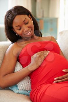 Pregnant Woman Relaxing On Sofa At Home