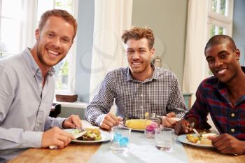 Male Friends At Home Sitting Around Table For Dinner Party