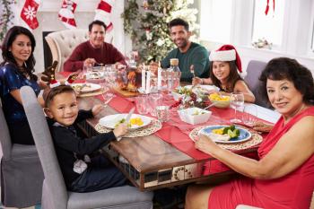 Family With Grandparents Enjoying Christmas Meal At Table