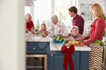 Family With Grandparents Preparing Christmas Meal In Kitchen