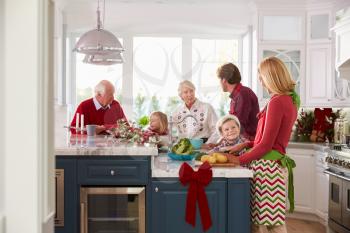 Family With Grandparents Preparing Christmas Meal In Kitchen