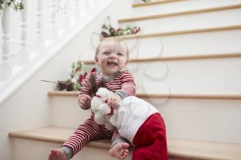 Young Girl On Stairs In Pajamas With Toy At Christmas