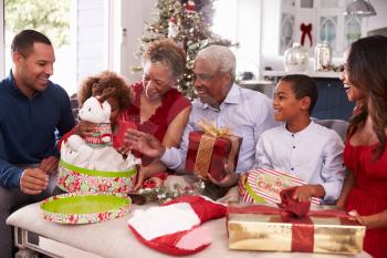 Family With Grandparents Opening Christmas Gifts