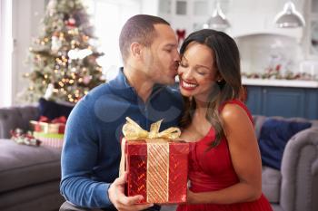 Romantic Couple Exchanging Christmas Gifts At Home