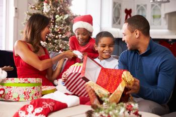 Family Opening Christmas Presents At Home Together
