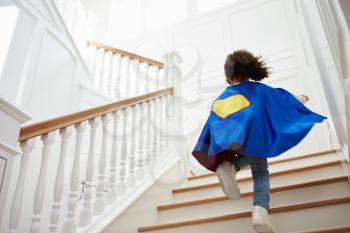 Girl Dressed Up As Superhero Playing Game On Stairs