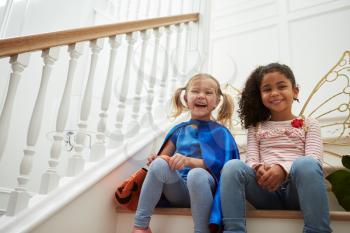 Two Girls Playing Dressing Up Games Sitting On Stairs