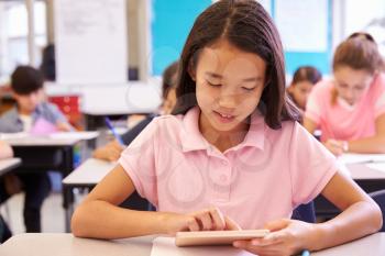 Schoolgirl using tablet computer in elementary school class