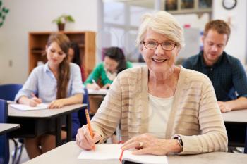 Happy senior woman at an adult education class looking to camera
