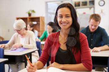 Hispanic woman at an adult education class looking to camera