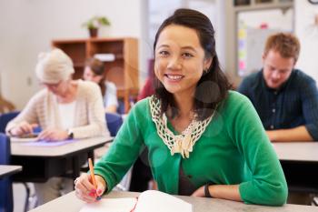 Asian woman in an adult education class looking to camera